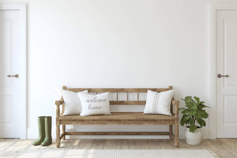 entryway. Wooden bench near white wall